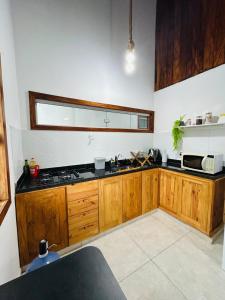 a kitchen with wooden cabinets and a stove top oven at Loft 2 quartos with full kitchen in Uruçuca +12 photos