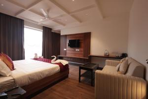 a hotel room with a bed and a couch at KG Residency Inn in Thanjāvūr +29 photos