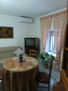 a living room with a table and a tv at Casa Lara - Sierra de Cazorla in Quesada