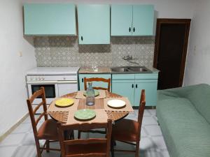 a kitchen with a table and chairs and a kitchen with blue cabinets at Casa Lara - Sierra de Cazorla in Quesada