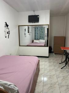 a bedroom with a bed and a tv on the wall at 88 Inn in Upper Katungal