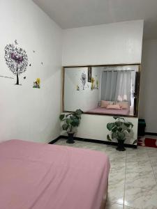 a bedroom with a bed and a window with plants at 88 Inn in Upper Katungal