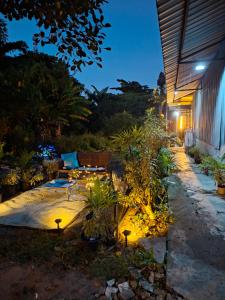a backyard patio with a bench and plants at night at Budget Place Homestay-Solo Traveler in Ban Dan