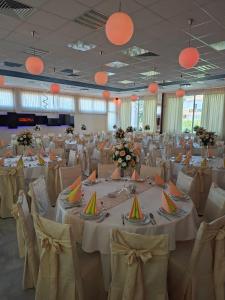 a banquet hall with white tables and chairs and orange lights at Motel Kruna in Despotovac