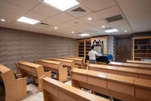 Ein Mann steht in einem Raum mit Schreibtischen und Stühlen. in der Unterkunft Palm Beach Hotel - Mehadrin Kosher suitable for Ultra-Orthodox guests in Akkon + 48 Fotos