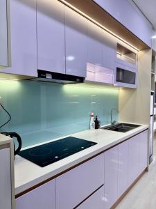 a kitchen with white cabinets and a sink at Phú Tài Central Life in Quy Nhon