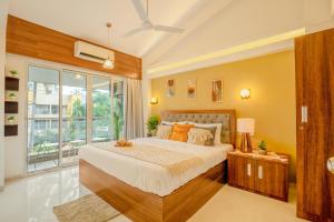 a bedroom with a large bed and a large window at Charvi Reemz Anjuna in Anjuna +29 photos