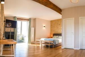 a bedroom with a bed and a table at SALVEO Suites in Loubens