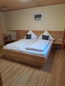 a bedroom with a large bed with blue sheets at Hotel Bärenhof in Philippsreut