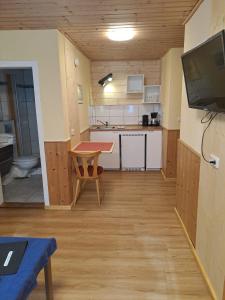 a kitchen with a table and a television in a room at Hotel Bärenhof in Philippsreut