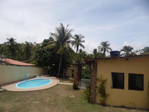 ein Swimmingpool in einem Garten neben einem Haus in der Unterkunft Bitingui infinity in Japaratinga + 13 Fotos