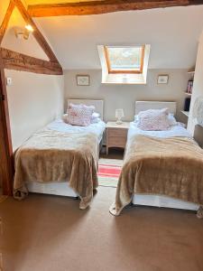 a bedroom with two beds and a window at Llanerch in Bala