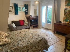 a bedroom with a bed and a couch and a fireplace at Bel Horizon in La Celle-sous-Gouzon
