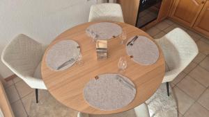a wooden table with four white chairs around it at Summit & Spring Studio - Leukerbad in Leukerbad +11 photos