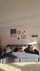 a living room with a blue couch with pillows at Summit & Spring Studio - Leukerbad in Leukerbad
