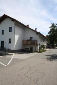 a white building with a deck on the side of it at Hotel Bärenhof in Philippsreut +10 photos