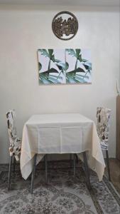 a dining room table with a white tablecloth and two chairs at The Cozy Place Stanford 2 in Silang