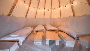 ein Zelt mit vier Betten und Lampen in der Unterkunft Moon Glamping in Benczyn