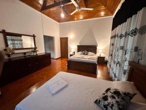 a large room with two beds and a mirror at Kandy Villa in Kandy
