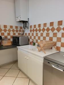 a kitchen with a sink and a microwave at entre arènes et maison carrée in Nîmes