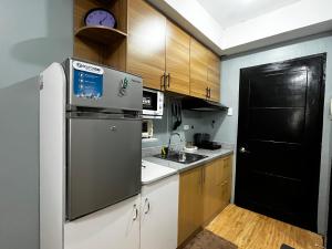 a kitchen with a refrigerator and a sink at JAN Studio CDO Condo Stay in Lapasan