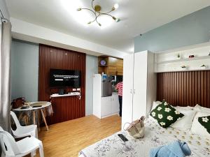 a bedroom with a bed and a kitchen with a refrigerator at JAN Studio CDO Condo Stay in Lapasan