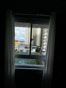 a window with a view of a building at JAN Studio CDO Condo Stay in Lapasan