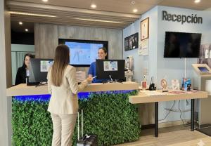 a woman standing at a reception desk in a store at ibis budget Santiago Providencia in Santiago