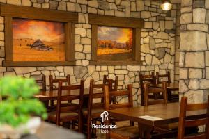 a restaurant with tables and chairs and paintings on the wall at Hotel Residence Travnik in Travnik