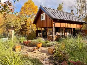 a small wooden house in the middle of a garden at Magical Wellness Cottage Trvalka in Křimov