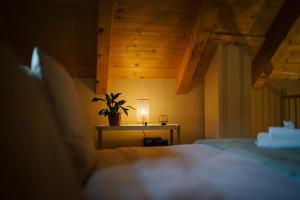 a bedroom with a table with a plant and a lamp at Magical Wellness Cottage Trvalka in Křimov