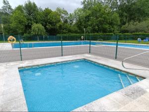 a swimming pool with a fence around it at Chalet adosado con piscina en el Valle de Asón LA TUDANCA in Arredondo