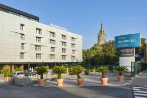 a row of palm trees in front of a building at Occidental Bilbao in Bilbao