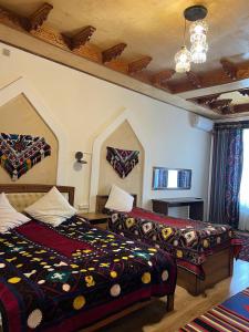 a bedroom with two beds and a chandelier at Anoragul guest house in Shahrisabz