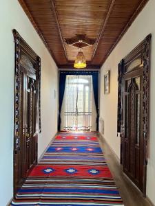 a hallway with a rug on the floor and two doors at Anoragul guest house in Shahrisabz