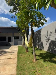a hammock hanging between two trees in a yard at Caminho do mar in Itanhaém