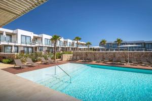 a swimming pool with chairs and a resort at Barceló Nura in Sant Lluis