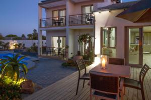 Casa con terraza con mesa y sillas en Ocean Bay Guesthouse en Puerto Elizabeth