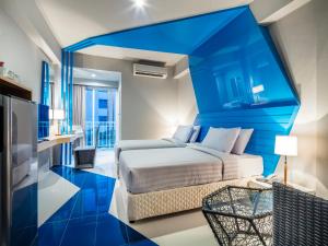 a bedroom with a bed and a blue wall at Atelier Suites in Bangkok