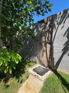a shadow of a tree on the side of a building at Caminho do mar in Itanhaém