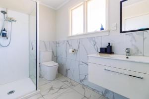 a bathroom with a toilet and a sink and a shower at Belle Bonne Motel in Christchurch