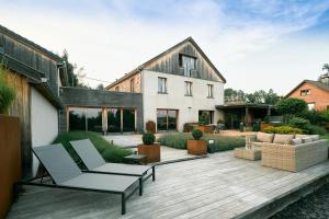 a house with a deck with a chair and a couch at Oklm6 in Mellet