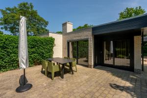 a patio with a table and chairs and an umbrella at Zeebries in De Koog