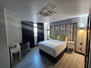 ein Schlafzimmer mit einem Bett, einem Tisch und einem Stuhl in der Unterkunft Print Works Hotel in Liverpool