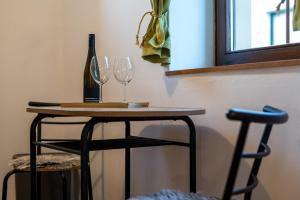 a table with two wine glasses and a bottle at Apartmány U Parku in Vrchlabí +17 photos