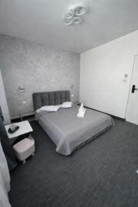 a bedroom with a large bed and a ceiling fan at Hotel AmA in Constanţa +7 photos