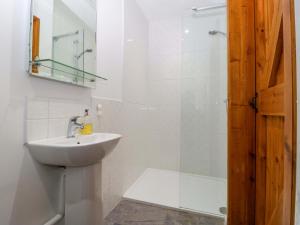 ein weißes Badezimmer mit Waschbecken und Dusche in der Unterkunft Castle Rag in Lydney + 21 Fotos
