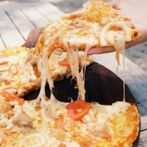 una persona está sosteniendo una porción de pizza en Laguna Gili, en Gili Trawangan