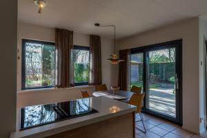 a kitchen with a table and some windows at Zeebries in De Koog
