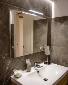 a bathroom with a sink and a mirror at Palazzo Fiammingo Rooms in Belpasso
